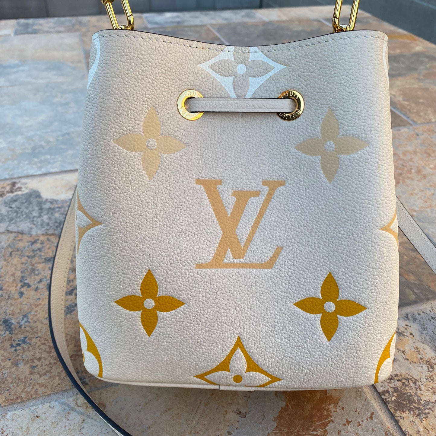 LOUIS VUITTON Empreinte Monogram Giant By The Pool Neonoe BB in Cream and  Saffron. This classic bucket-style shoulder bag features…